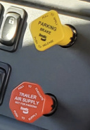 Yellow parking brake and red trailer air supply controls